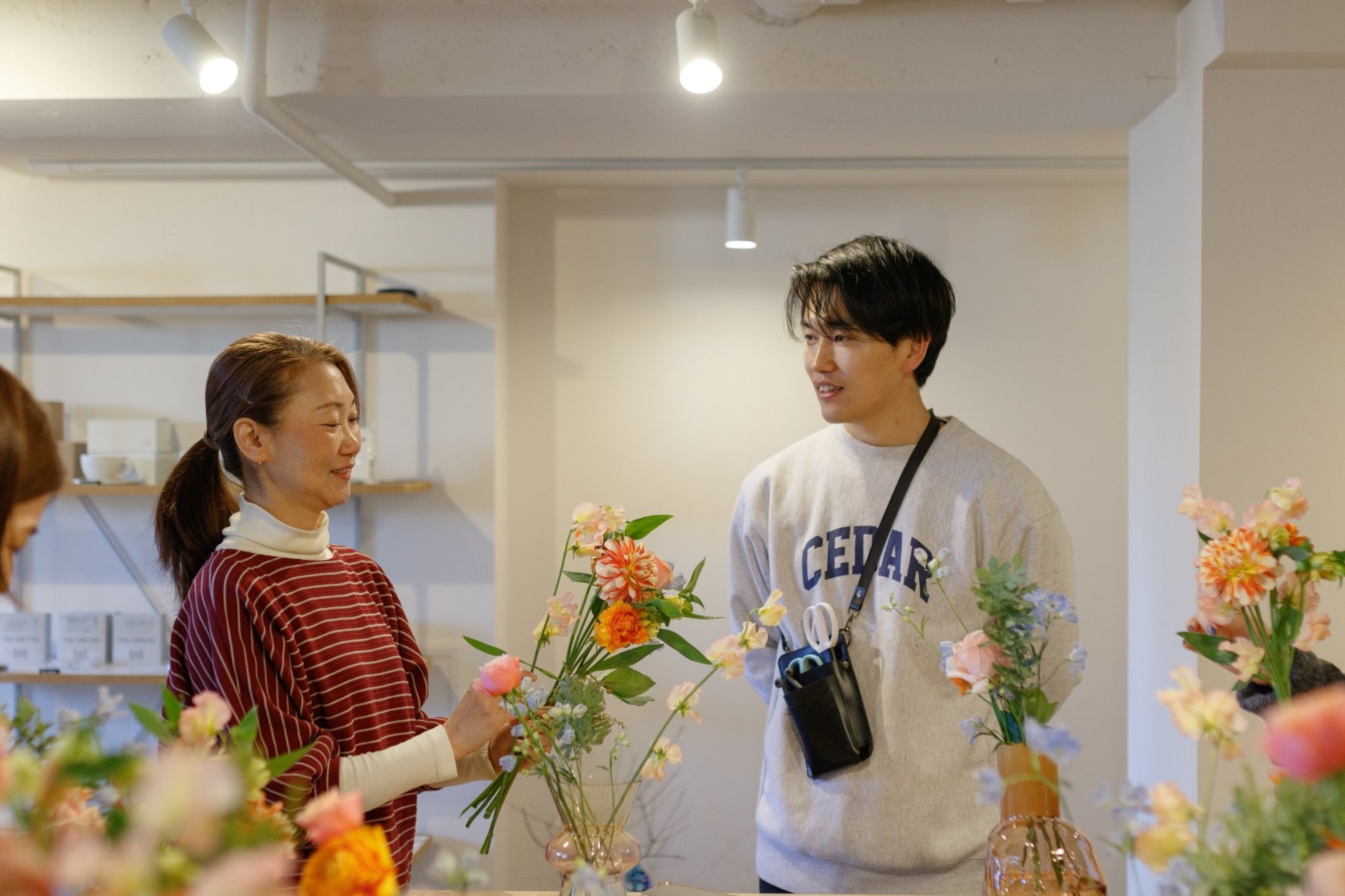 花活JAPAN ワークショップの様子。FLOWER NAOKI と参加者が季節のお花を束ねる。